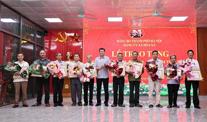Phó Bí thư Thường trực Đảng ủy xã Hòa Xá Trần Duyên Hải trao Huy hiệu Đảng tặng các đảng viên. Ảnh: Thanh Hằng
