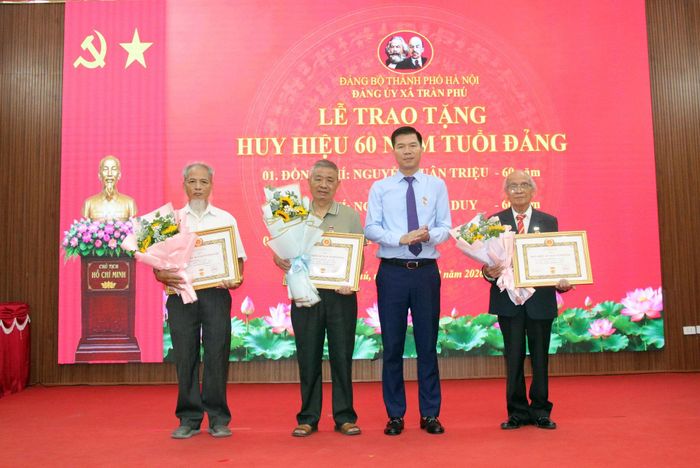 Bí thư Đảng ủy, Chủ tịch HĐND xã Nguyễn Nguyên Hùng trao Huy hiệu 60 năm tuổi Đảng tặng các đảng viên. Ảnh: HĐ