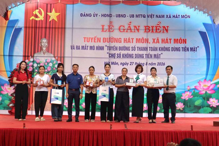Đại diện các Ngân hàng tặng tiểu thương mã QR thực hiện thanh toán không dùng tiền mặt. Ảnh: NM