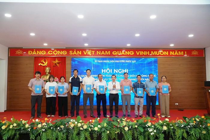 Phó Chủ tịch UBND phường Phúc Lợi Bùi Anh Tuấn trao quyết định thành lập các Tổ công nghệ số cộng đồng. Ảnh: Nguyễn Bình