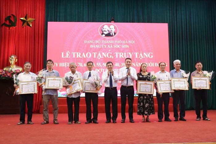 Thường trực Đảng uỷ xã Sóc Sơn trao tặng Huy hiệu Đảng cho các đảng viên. Ảnh: CTV.