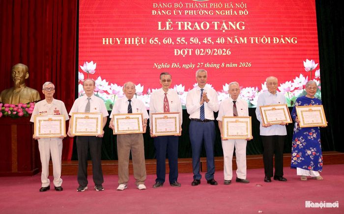 Bí thư Đảng ủy phường Nghĩa Đô Nguyễn Hồng Sơn trao Huy hiệu Đảng tặng các đảng viên. Ảnh: MT