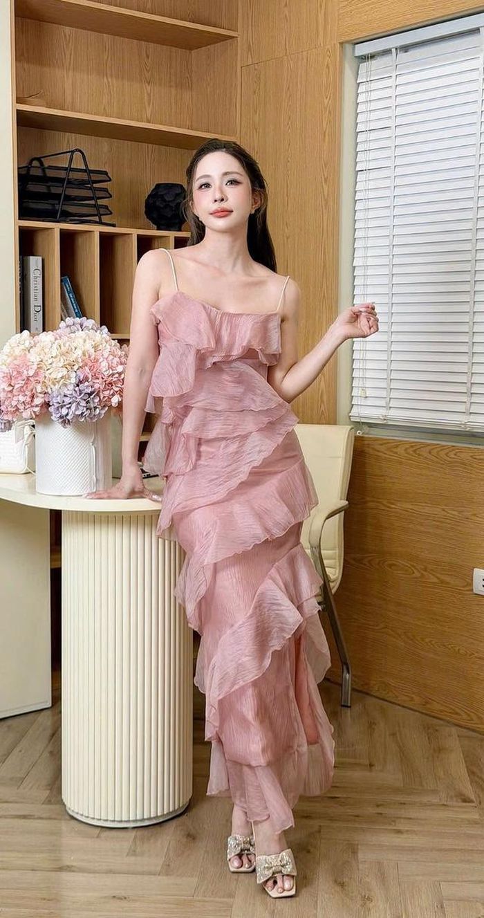 Quỳnh Nga diện chiếc váy hai dây màu hồng với thiết kế xếp tầng bồng bềnh. Trang phục giúp nữ diễn viên khoe bờ vai thon cùng làn da trắng sáng, đồng thời mang đến vẻ ngoài trẻ trung, tươi mới.