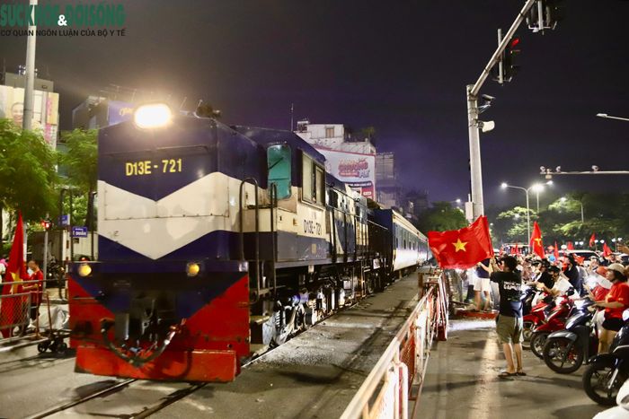 Đoàn tàu đi qua khu vực đường Lê Duẩn, tiếng hô “Việt Nam vô địch” vang lên từ các toa tàu đầy tự hào. (Ảnh Thành Long)
