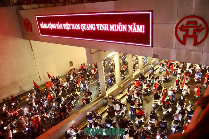 Từ khu vực quanh sân Mỹ Đình, từng đoàn người mang theo cờ Tổ quốc, áo đấu, băng rôn và các vật dụng cổ vũ bắt đầu di chuyển về trung tâm thành phố. (Ảnh Thành Long)