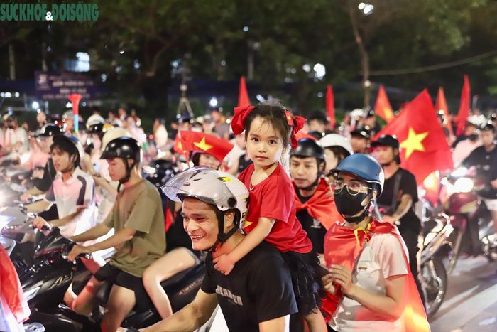 Nhiều gia đình, nhóm bạn trẻ cũng xuống đường hòa vào dòng người. Không ít người tranh thủ dùng điện thoại ghi lại những khoảnh khắc đặc biệt sau trận đấu. (Ảnh Thành Long)