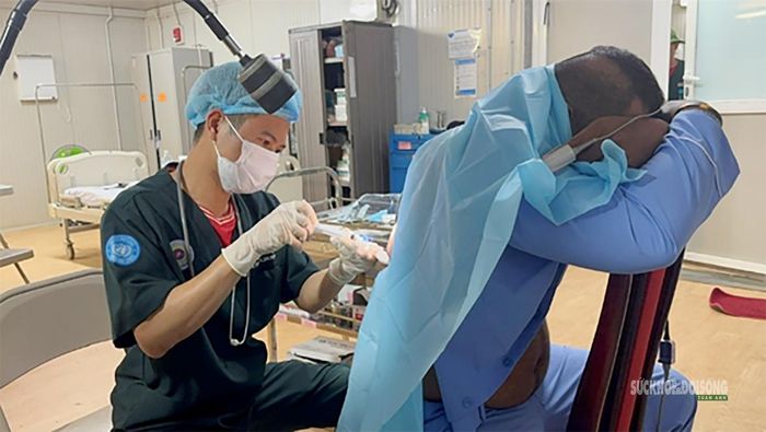 Đại úy, Bác sĩ Nguyễn Công Trường thực hiện thủ thuật chọc, hút dịch cho bệnh nhân. Ảnh: Văn Giang