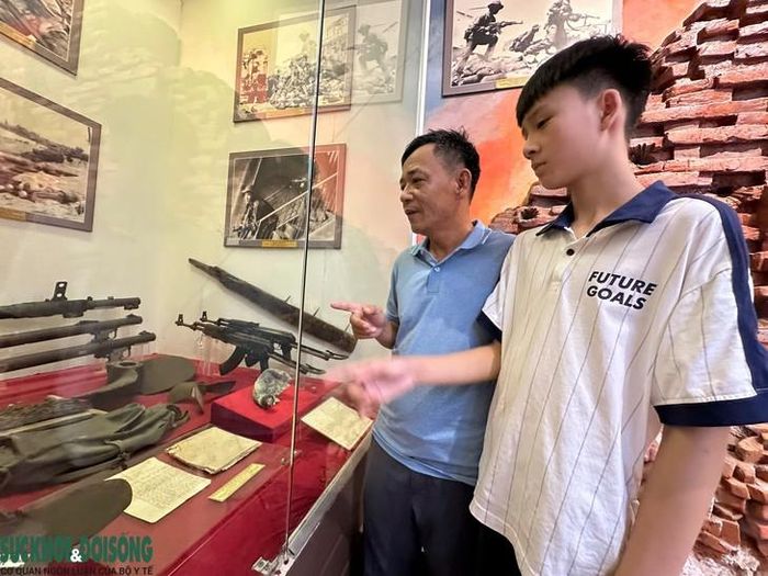 Ông Đào Xuân Hiệu (SN 1975, cháu ruột liệt sĩ Kã) cùng con trai xúc động bên bức thư của người cậu.