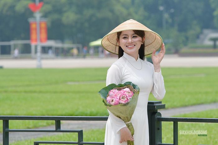 Áo dài trắng và hoa sen tạo nét dịu dàng giữa Quảng trường Ba Đình.