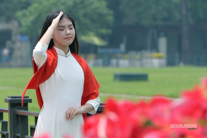Thiếu nữ trong tà áo dài trắng, khoác cờ Tổ quốc chụp ảnh lưu niệm trước Lăng Chủ tịch Hồ Chí Minh.