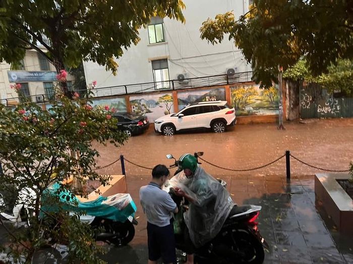 Một con ngõ trên phố Dương Đình Nghệ, nước ngập sát với vỉa hè. Ảnh: Hoa Đinh