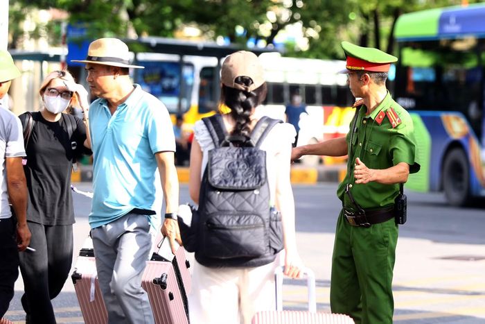 Cảnh sát trật tự tận tình hướng dẫn người dân di chuyển, vào khu vực mua vé tại bến xe, góp phần bảo đảm trật tự, thuận tiện cho hành khách
