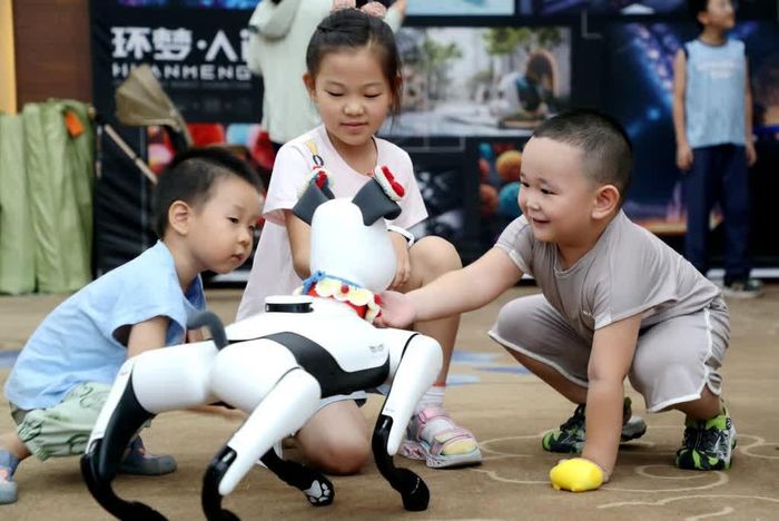  Trẻ em chơi đùa cùng thú cưng robot tại triển lãm trí tuệ nhân tạo ở Đông Dinh, tỉnh Sơn Đông, ngày 3/8/2025. Ảnh: Liu Zhifeng/Xinhua.