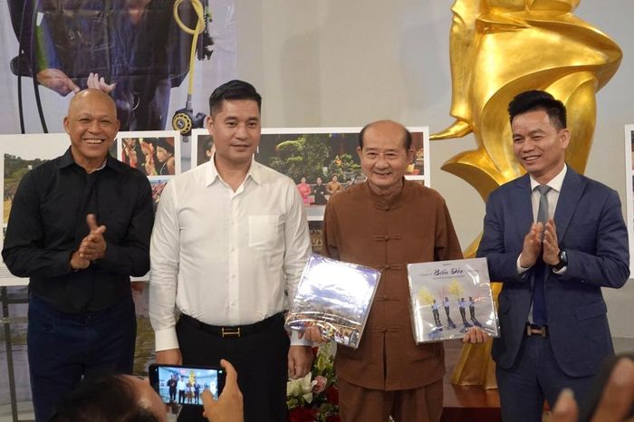  Nhiếp ảnh gia Nguyễn Á (ngoài cùng bên trái) và đại diện các đơn vị đồng hành đã tặng hai cuốn sách ảnh cho nghệ nhân. Ảnh: Phan Chi.