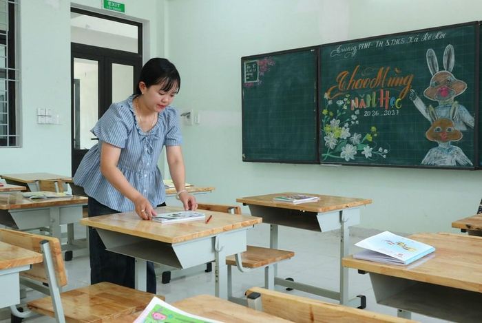 Tranh thủ giờ ra chơi, cô giáo tranh thủ sắp xếp lại vở viết trên bàn học cho các em học sinh lớp 1