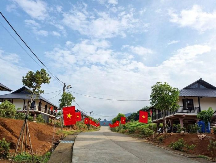 Từ trên cao, những mái nhà nối với nhau bằng các tuyến đường bê tông sạch đẹp, được điểm tô bởi sắc đỏ cờ Tổ quốc, tạo nên điểm nhấn nổi bật giữa không gian xanh của núi rừng