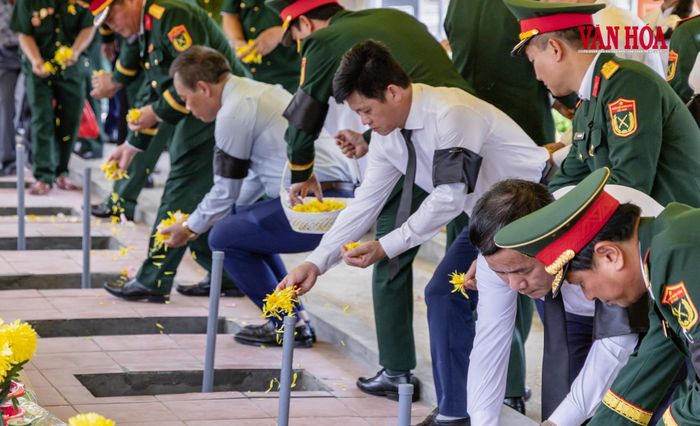 Hoa được rải xuống phần mộ trong giờ phút tiễn biệt, như lời tri ân dành cho những người đã gửi lại tuổi xuân nơi chiến trường