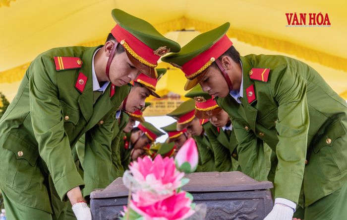 Những chiến sĩ trẻ nâng hài cốt liệt sĩ về vị trí an táng, từng động tác được thực hiện cẩn trọng và trang nghiêm
