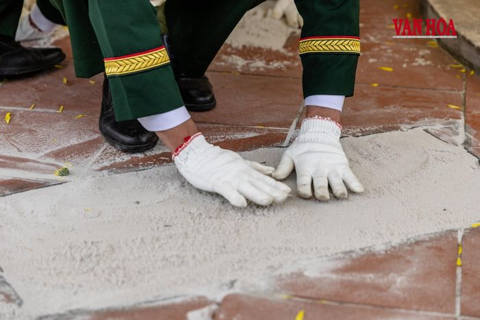 Đôi tay người lính cẩn trọng san lại lớp đất trên phần mộ đồng đội, một chi tiết nhỏ nhưng gợi nhiều xúc cảm trong phút cuối lễ an táng