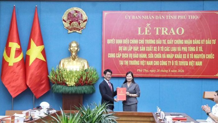 Bà Vương Thị Bẩy, Giám đốc Sở Tài chính tỉnh Phú Thọ trao Giấy chứng nhận đăng ký đầu tư điều chỉnh dự án của Công ty Ô tô Toyota Việt Nam cho ông Osamu Hirata, Tổng giám đốc Công ty tại chương trình