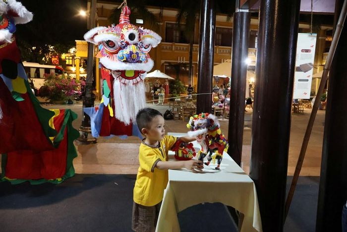 Một bạn nhỏ say mê với không gian giới thiệu nghề làm đầu lân, thiên cẩu truyền thống
