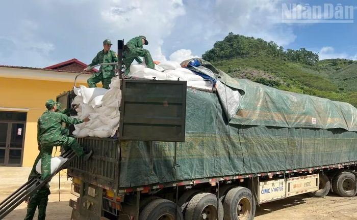 Cán bộ, chiến sĩ Đồn Biên phòng Chiềng On giúp Trường phổ thông nội trú tiểu học và trung học cơ sở Yên Sơn tiếp nhận và vận chuyển xe gạo 60 tấn chuẩn bị cho bếp ăn nội trú. (Ảnh: QUÀNG HÙNG)