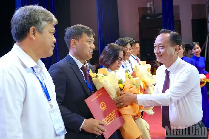 Đồng chí Phạm Văn Thiều, Phó Bí thư Tỉnh ủy, Chủ tịch Ủy ban nhân dân tỉnh Cà Mau (bìa phải) tặng hoa chúc mừng các doanh nghiệp được tỉnh Cà Mau chấp thuận chủ trương đầu tư. (Ảnh: HỮU TÙNG)