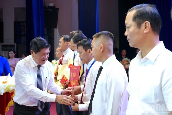 Phó Chủ tịch Ủy ban nhân dân tỉnh Cà Mau Lê Văn Sử (bìa trái) trao quyết định và tặng hoa chúc mừng các doanh nghiệp được tỉnh Cà Mau chấp thuận chủ trương đầu tư. (Ảnh: HỮU TÙNG)