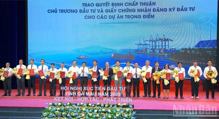 Lãnh đạo tỉnh Cà Mau chụp ảnh lưu niệm với 19 nhà đầu được trao quyết định chấp thuận chủ trương đầu tư tại hội nghị. (Ảnh: HỮU TÙNG)