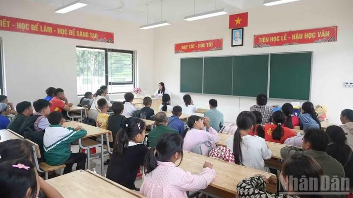 Thầy, cô giáo hướng dẫn phụ huynh và các em học sinh làm thủ tục, nhận lớp, nhận phòng và ổn định nơi ăn ở. (Ảnh: CÔNG HẢI)