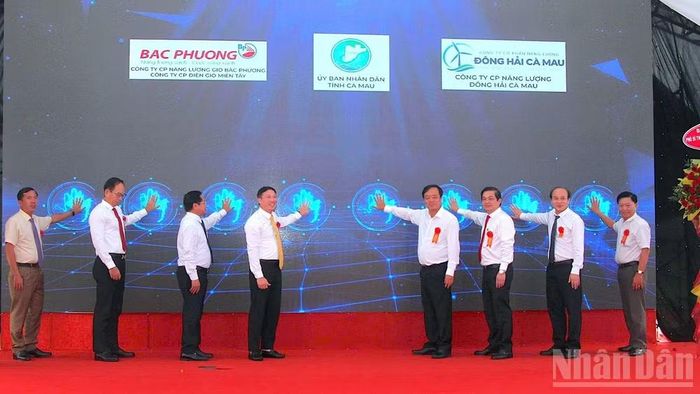 Phó Bí thư Thường trực Tỉnh ủy Cà Mau Huỳnh Quốc Việt (thứ 4 từ phải qua) cùng các lãnh đạo tỉnh và nhà đầu tư thực hiện nghi thức bấm nút khởi động dự án. (Ảnh: HỮU TÙNG)