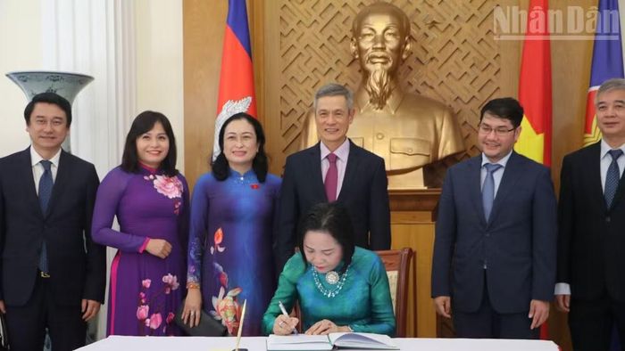 Phó Chủ tịch Quốc hội Nguyễn Thị Thanh viết lưu bút tại Đại sứ quán Việt Nam tại Campuchia. (Ảnh: HUY VŨ)