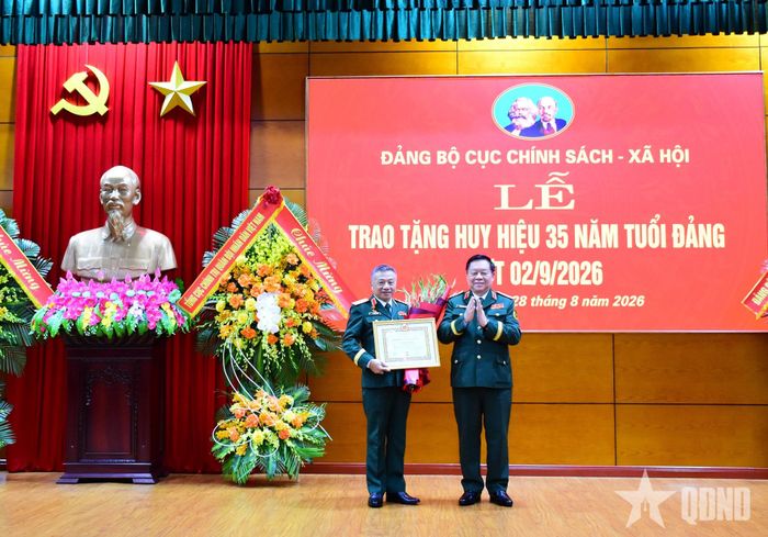 Đại tướng Nguyễn Trọng Nghĩa trao Huy hiệu 35 năm tuổi Đảng và tặng hoa chúc mừng Thượng tướng Lê Quang Minh.