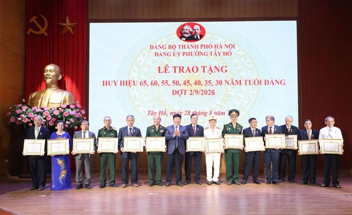 Lãnh đạo thành phố và lãnh đạo phường Tây Hồ trao Huy hiệu Đảng tặng các đảng viên lão thành.  