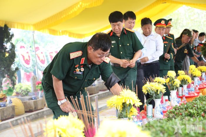 Các cựu chiến binh, nhân dân dâng hương tại các phần mộ liệt sĩ.  