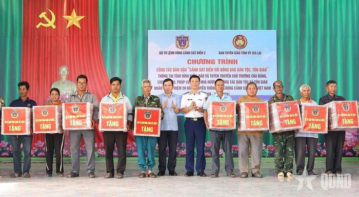  Đại tá Trần Hồng Quế, Phó chính ủy Vùng Cảnh sát biển 2 và đồng chí Phạm Huy Toàn, Phó trưởng Ban Tuyên giáo Tỉnh ủy Gia Lai trao quà tặng người có uy tín trong cộng đồng các dân tộc, tôn giáo.  