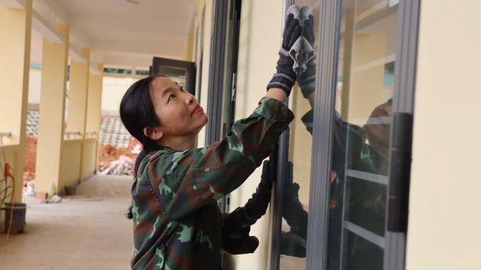 Cán bộ, chiến sĩ lau chùi cửa kính. Ảnh: HỮU PHÚC