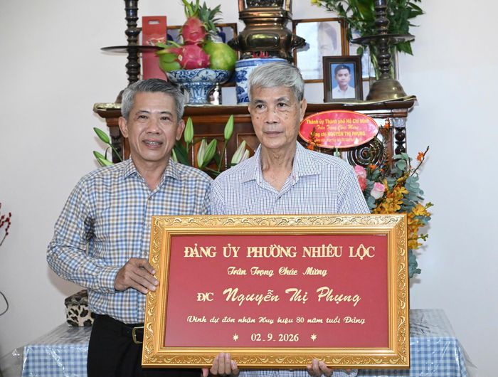 Thông qua người thân trong gia đình, lãnh đạo phường Nhiêu Lộc chúc mừng đến đồng chí Nguyễn Thị Phụng. Ảnh: VIỆT DŨNG