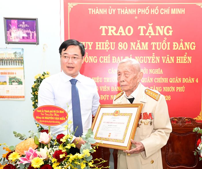  Đồng chí Lê Quốc Phong trao Huy hiệu 80 năm tuổi Đảng đến đồng chí Nguyễn Văn Hiển. ﻿Ảnh: VĂN MINH 