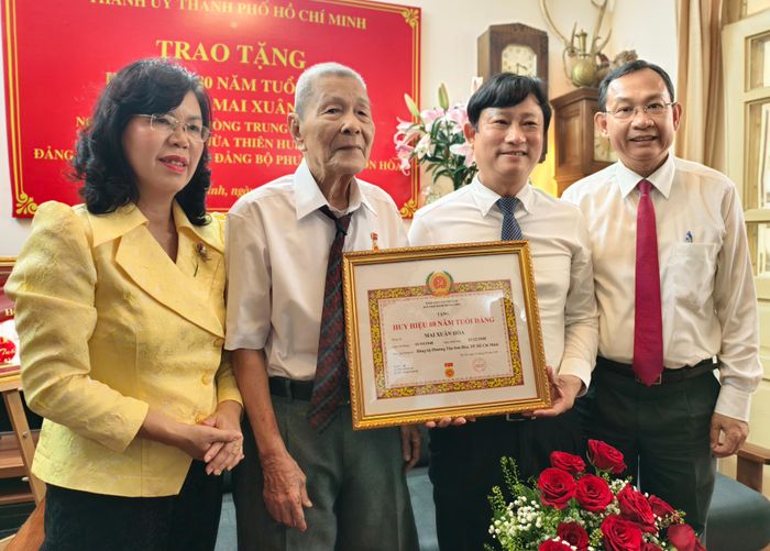  Đồng chí Võ Văn Minh trao Huy hiệu 80 năm tuổi Đảng cho đồng chí Mai Xuân Hòa. Ảnh: NGUYỄN TÂN 