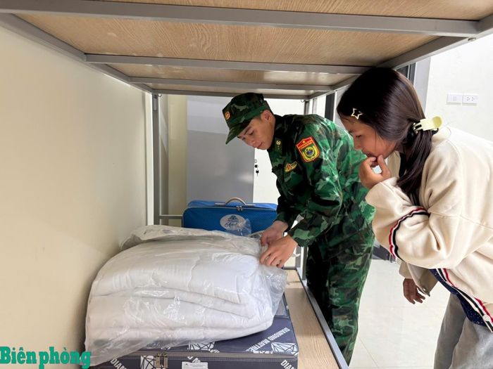 Cán bộ Đồn Biên phòng Mường Cai hướng dẫn các cháu học sinh nội trú về cách gấp chăn màn. Ảnh: Quàng Hùng