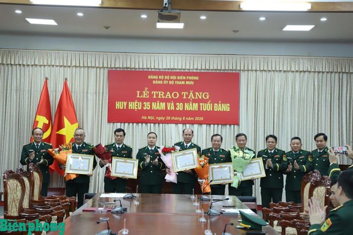Đại tá Vũ Văn Hưng chúc mừng các đảng viên được nhận Huy hiệu 35 năm và 30 năm tuổi Đảng. Ảnh: Ngọc Lâm