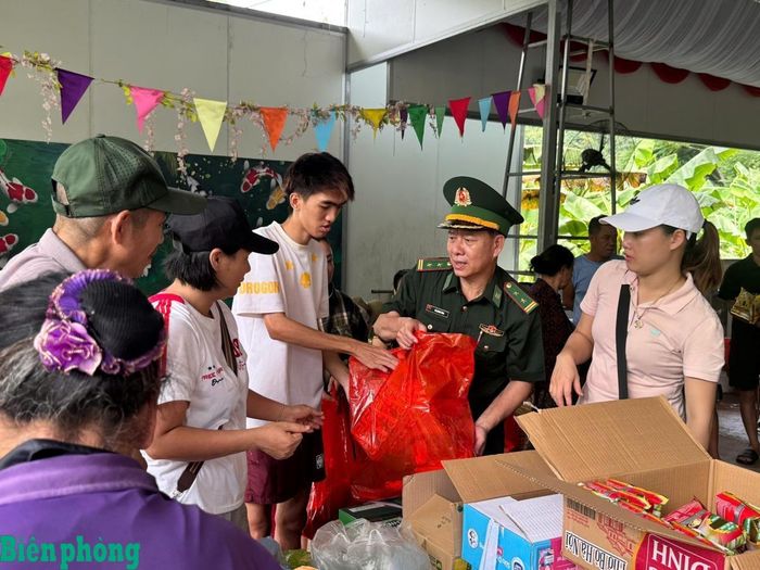 Cán bộ, chiến sĩ Đồn Biên phòng Cát Bà trao nhu yếu phẩm hỗ trợ nhân dân thôn Gia Luận bị ảnh hưởng bởi ngập lụt do bão số 4. Ảnh: Nguyễn Khánh