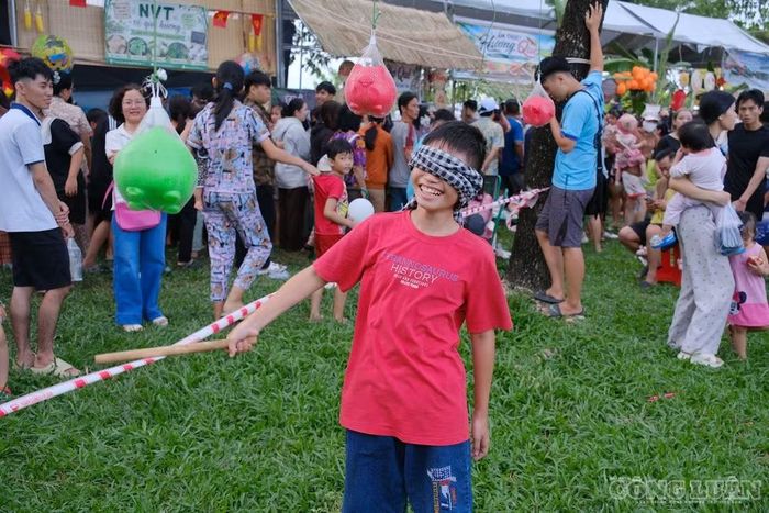 Một bạn nhỏ thích thú chơi đập heo.