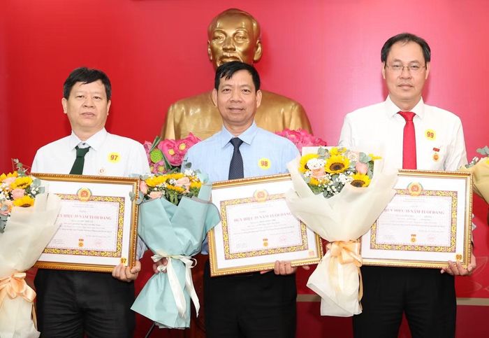 Phó Chủ tịch Ủy ban MTTQ Việt Nam TPHCM Nguyễn Thành Trung (bìa phải) nhận Huy hiệu 35 năm tuổi Đảng.