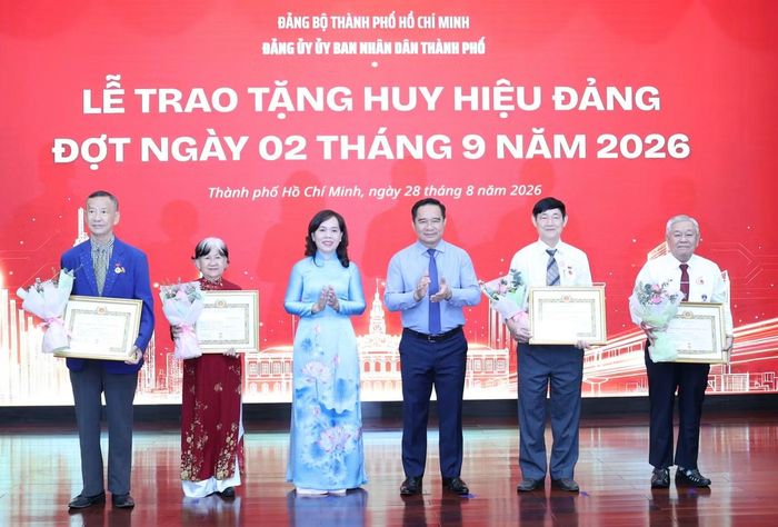 Ông Nguyễn Văn Được cùng Phó Bí thư Đảng ủy UBND TPHCM - Nguyễn Thanh Xuân - trao Huy hiệu 45 năm tuổi Đảng tặng các đảng viên.