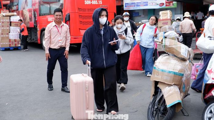 Khu vực sảnh chờ và các lối dẫn vào khu vực xe xuất bến có rất nhiều hành khách kéo vali, mang ba lô, túi xách và nhiều đồ đạc.