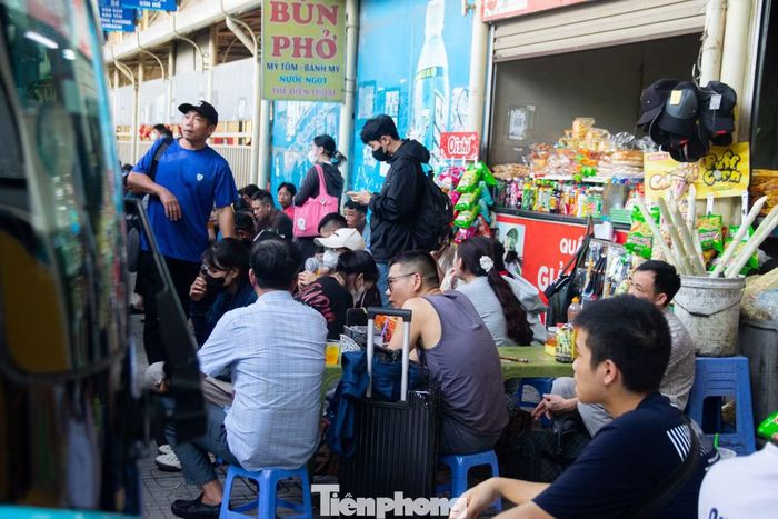 Người dân lỉnh kỉnh ba lô, túi xách, kiên nhẫn ngồi chờ đến giờ xe xuất bến để về quê.