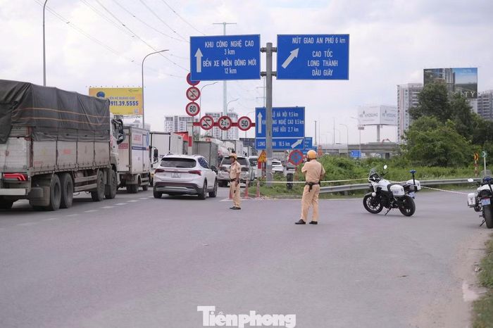 CSGT Đội Cát Lái điều tiết phương tiện tại khu vực vòng xoay Phú Hữu nhằm giảm áp lực lên cao tốc. Ảnh: Nguyễn Tiến