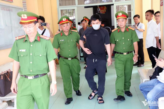 Sau khi HĐXX quyết định hoãn phiên tòa, bị cáo được lực lượng công an hỗ trợ dìu ra khỏi phòng xét xử. 